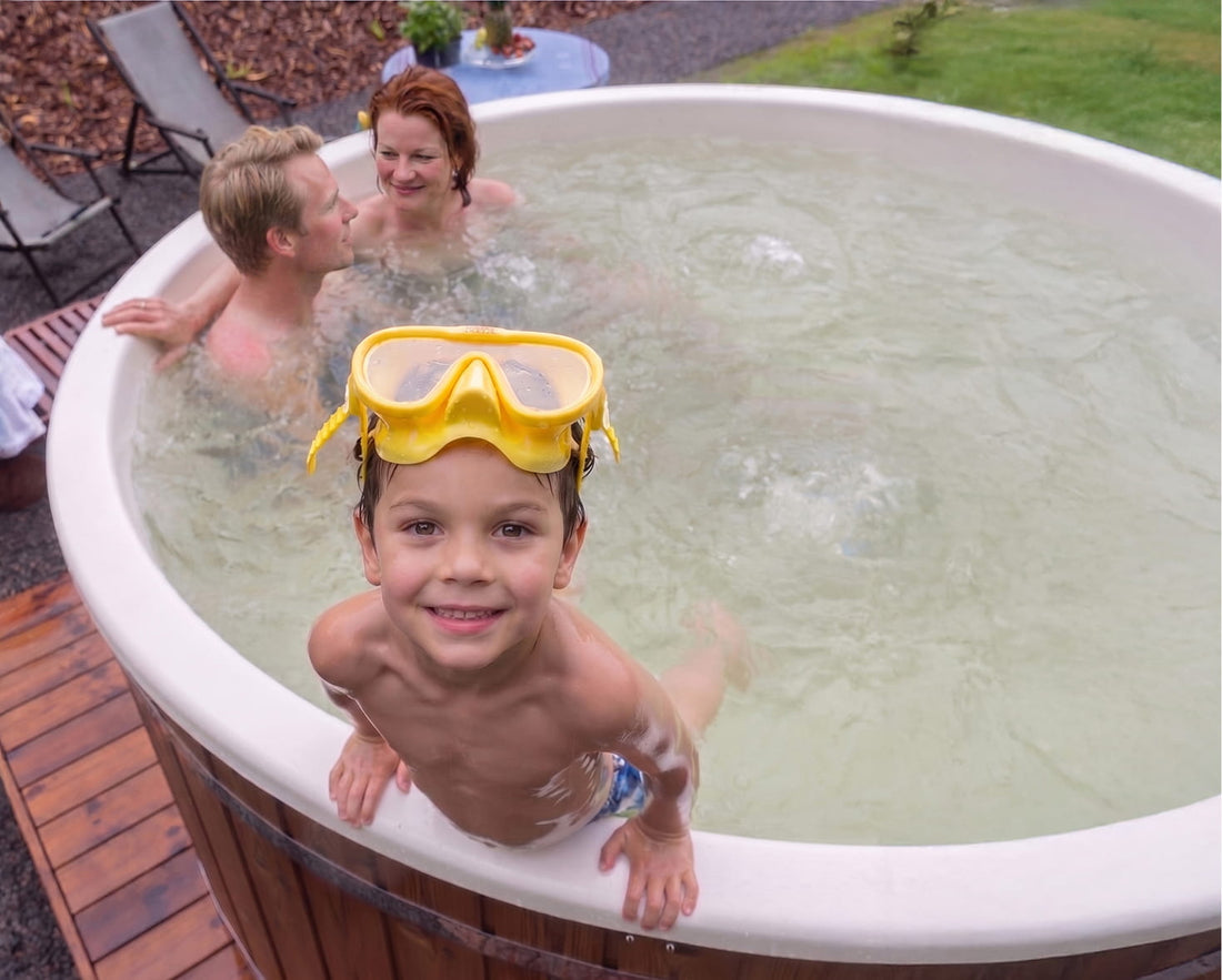 Kind badet mit seinen Eltern in einem Hot Tub mit weißer Innenwanne