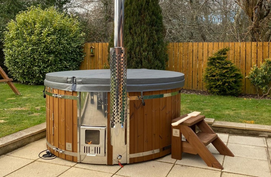 Auf der Terrasse befindet sich ein runder, überdachter Hot Tub mit Standardtreppe und integriertem Ofen.