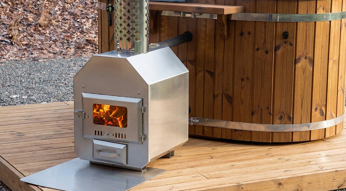 Holzofen auf einer Holzterrasse mit Hot Tub im Hintergrund