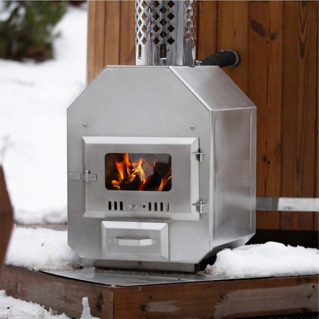 Externer Holzofen mit sichtbarem Feuer in einer verschneiten Outdoor-Umgebung
